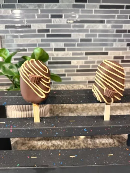 Peanut butter cup cakesicles on a black display stand