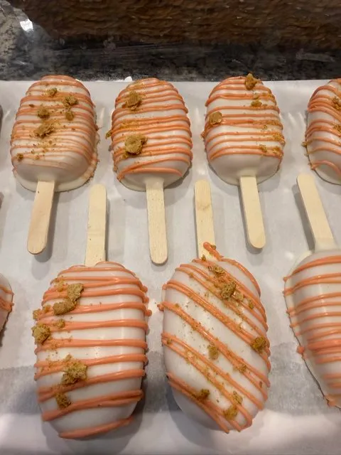 Vanilla-dipped cakesicles with orange drizzle and cookie crumbs